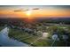 Aerial view of a waterfront community at sunset, showcasing homes and marsh views at 3067 Marshgate Dr, Seabrook Island, SC 29455