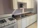 Efficient kitchen features white cabinets, gas range, and granite countertops at 9 Addison St, Charleston, SC 29403