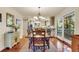 Bright dining room with hardwood floors, chandelier, and access to deck at 202 Needlerush Rd, Kiawah Island, SC 29455
