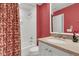 Small bathroom with a shower/tub combo, vanity with granite countertop, and red walls at 202 Needlerush Rd, Kiawah Island, SC 29455