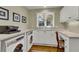 Laundry room with white cabinets, built-in workspace, and washer/dryer at 202 Needlerush Rd, Kiawah Island, SC 29455