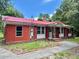 Brick ranch house with red metal roof, shutters, and a paved walkway at 2042 Sniders Highway, Walterboro, SC 29488