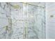 Spa-like shower with marble tile, glass enclosure, and gold accents at 3820 Gardenhill Rd, Mount Pleasant, SC 29429