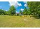 Large backyard with lush green grass, mature trees, and raised garden beds at 3820 Gardenhill Rd, Mount Pleasant, SC 29429