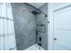 Shower with gray tile surround, black rain shower head, and built-in shelf at 3820 Gardenhill Rd, Mount Pleasant, SC 29429