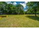Spacious backyard with large grassy area, mature trees, and garden beds at 3820 Gardenhill Rd, Mount Pleasant, SC 29429