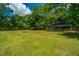 Large backyard with grassy area, mature trees, and fire pit at 3820 Gardenhill Rd, Mount Pleasant, SC 29429