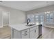 Kitchen island with white cabinets, quartz countertops and stainless steel dishwasher at 253 River Martin Ct, Summerville, SC 29483