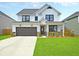 Two story farmhouse style home with white siding and dark accents at 537 Rendezvous Way, Huger, SC 29450