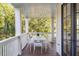 Relaxing outdoor porch with white furniture and a view of lush greenery at 108 Carolina Blvd, Isle of Palms, SC 29451