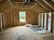 Unfinished attic space showing framing and a window with a view of trees at 111 Ashley Cove Way, Summerville, SC 29483