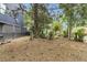 Overgrown side yard with mature trees and some clearing at 66 Cooper St, Charleston, SC 29403