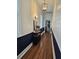 Long hallway with dark blue wainscoting and hardwood floors at 27 Allway St, Charleston, SC 29403