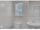 Clean bathroom with pedestal sink, toilet, and window at 124 Sweet Alyssum Dr, Ladson, SC 29456