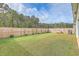 Large backyard with a grassy area, wooden fence, and small bench at 4383 Ocean Farm Dr, Summerville, SC 29485