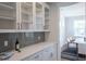 Butlers pantry with glass-front cabinets, gray tile backsplash, and quartz countertops at 383 Wappoo Trace Ln, Summerville, SC 29486