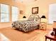 Cozy bedroom with hardwood floors, queen bed, and window seating at 8541 Oyster Factory Rd, Edisto Island, SC 29438
