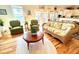 Spacious living room with hardwood floors, wicker furniture, and access to deck at 8541 Oyster Factory Rd, Edisto Island, SC 29438