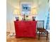 Charming entryway with red cabinet, lamps, and framed artwork at 8541 Oyster Factory Rd, Edisto Island, SC 29438