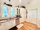 Bright kitchen featuring white cabinets, stainless steel dishwasher, and hardwood floors at 8541 Oyster Factory Rd, Edisto Island, SC 29438