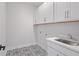 Laundry room with white cabinets, patterned floor, and utility sink at 1400 Dahlia Rd, Mount Pleasant, SC 29464