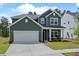Two story green house with rocking chairs on the porch at 4413 Palm Shadow Dr, Summerville, SC 29485