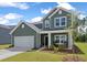 Two story green house with rocking chairs on the porch at 4413 Palm Shadow Dr, Summerville, SC 29485