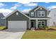 Two story green house with rocking chairs on the porch at 4413 Palm Shadow Dr, Summerville, SC 29485