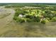 Aerial view showcasing expansive property, multiple buildings, and waterfront access at 6024 Selkirk Plantation Rd, Wadmalaw Island, SC 29487