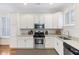 Modern white kitchen with stainless steel appliances and granite countertops at 291 Coming St, Charleston, SC 29403