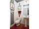 Small bathroom with pedestal sink, toilet, and floating shelf at 131 Tin Can Aly, Summerville, SC 29483