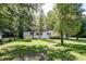 Mobile home surrounded by lush trees and a spacious yard at 121 Paisan Rd, Summerville, SC 29483