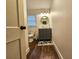 Clean bathroom with dark vanity, round mirror, and wood-look floors at 212 Hickory St, Walterboro, SC 29488