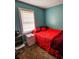 Simple bedroom with teal walls and red bedding at 212 Hickory St, Walterboro, SC 29488