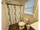Simple bathroom with shower/tub combo and dark wood-look floors at 212 Hickory St, Walterboro, SC 29488