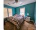 Spacious bedroom with teal walls, two windows, and a comfortable bed at 212 Hickory St, Walterboro, SC 29488