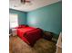 Bedroom with teal walls, window, and red bedding at 212 Hickory St, Walterboro, SC 29488