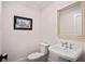 Elegant powder room with pedestal sink and frameless mirror at 16 42Nd Ave, Isle of Palms, SC 29451