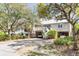 Two-story home with light beige siding, a metal roof, and a spacious driveway at 512 Carolina Blvd, Isle of Palms, SC 29451