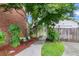 Landscaped side yard with a wooden gate and a bench at 11 Muirfield Village Ct, Summerville, SC 29483