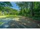 Large backyard with mature trees and a partially cleared area at 4418 Cindy Ln, North Charleston, SC 29418