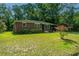 Brick ranch house with a spacious lawn, landscaped gardens and mature trees at 4418 Cindy Ln, North Charleston, SC 29418
