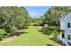 View of a grassy backyard with trees and a fence at 2312 Meridian Rd, North Charleston, SC 29405