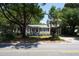 House with a large tree in front, attached garage, and elevated second floor at 1302 E Ashley Ave, Folly Beach, SC 29439