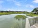 Tranquil waterfront view from deck showcasing marsh grasses and calm waters at 202 Mariners Cay Dr, Folly Beach, SC 29439