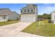 Two-story house with a gray and beige exterior, white garage door, and a well-maintained lawn at 242 Torslanda Ln, Summerville, SC 29486