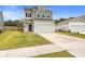 Two-story house with a gray and beige exterior, white garage door, and a well-maintained lawn at 242 Torslanda Ln, Summerville, SC 29486