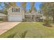 Attractive tan house with white garage door, landscaping, and a covered porch at 802 Long Drive Rd, Summerville, SC 29485