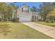 House exterior showcasing beige siding, a white garage door, and landscaping at 802 Long Drive Rd, Summerville, SC 29485