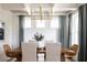 Elegant dining room with a wood table, blue curtains, and a statement light fixture at 1056 Capersview Ct, Awendaw, SC 29429